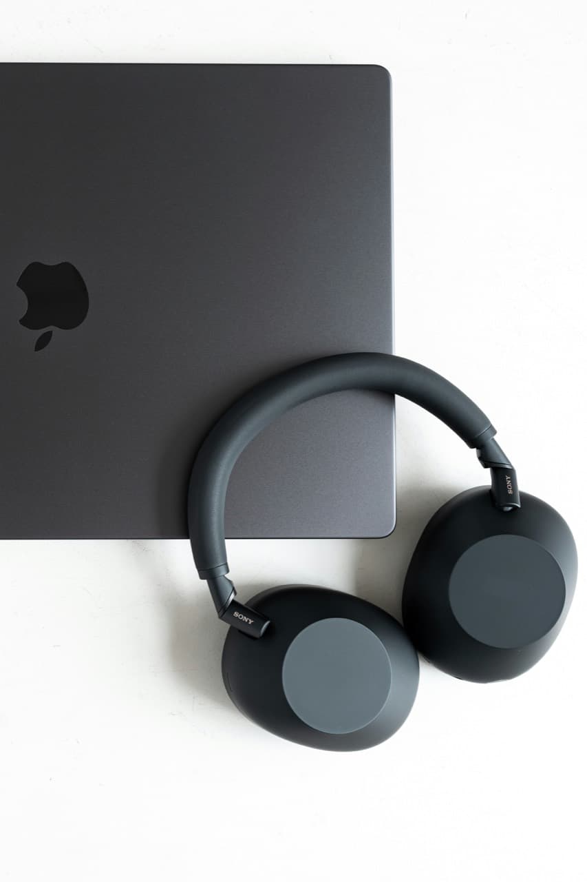 Fotografía contextual de auriculares Sony junto a un portátil, aportada desde Unsplash.